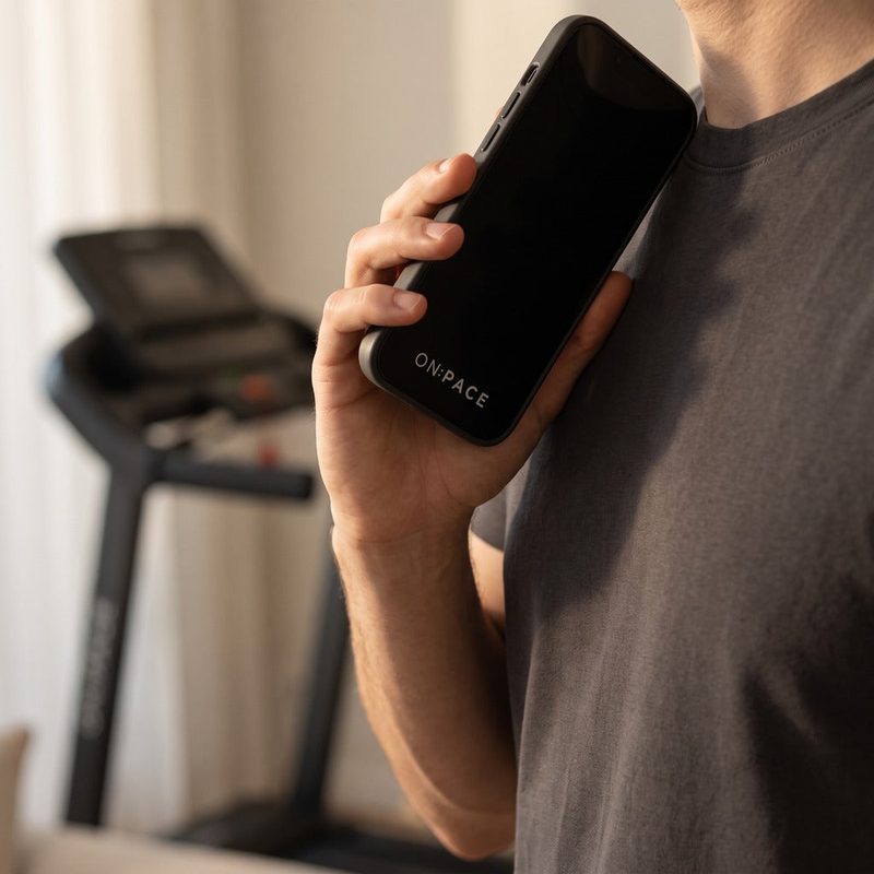 An ON:PACE owner on the phone beside their treadmill